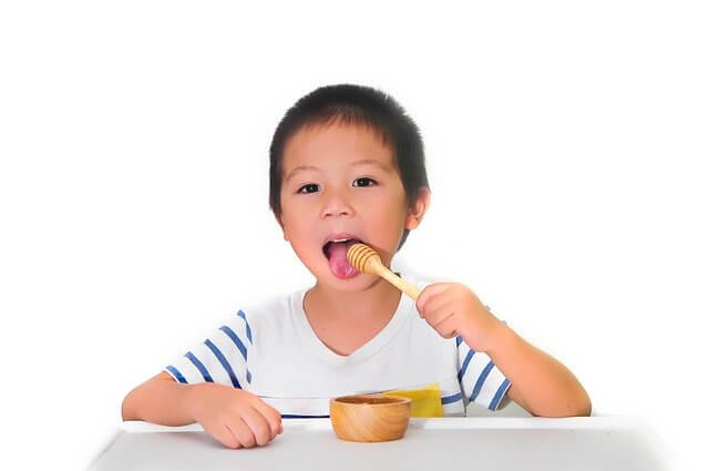 ハチミツを舐める子供